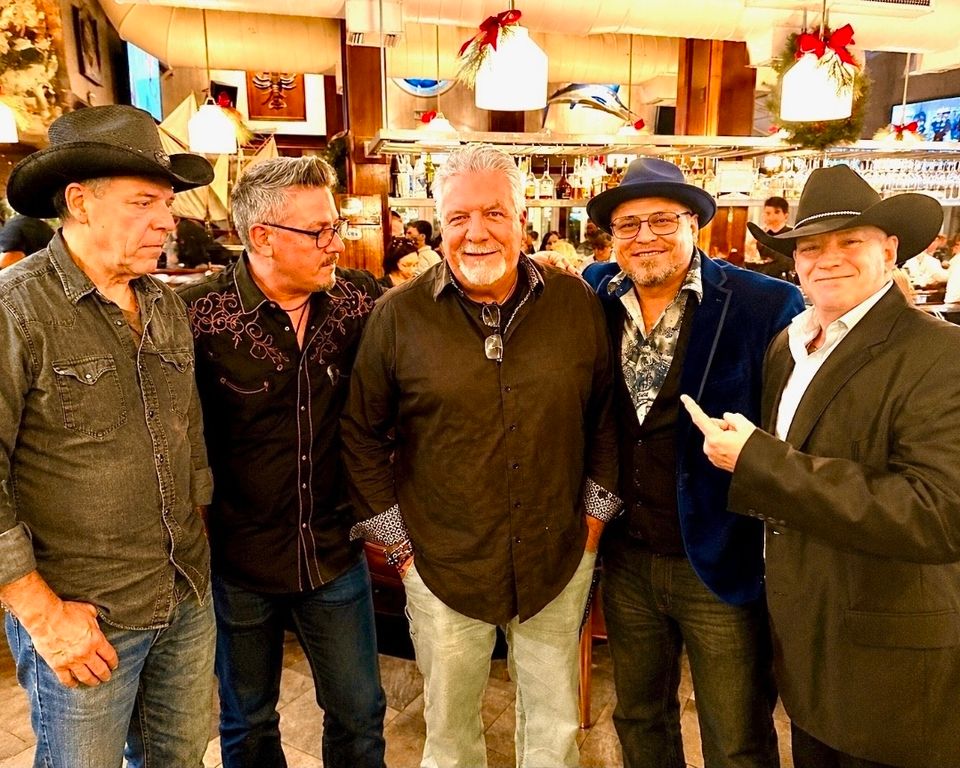 Five members of Roadside band posing together inside a restaurant before a private party gig