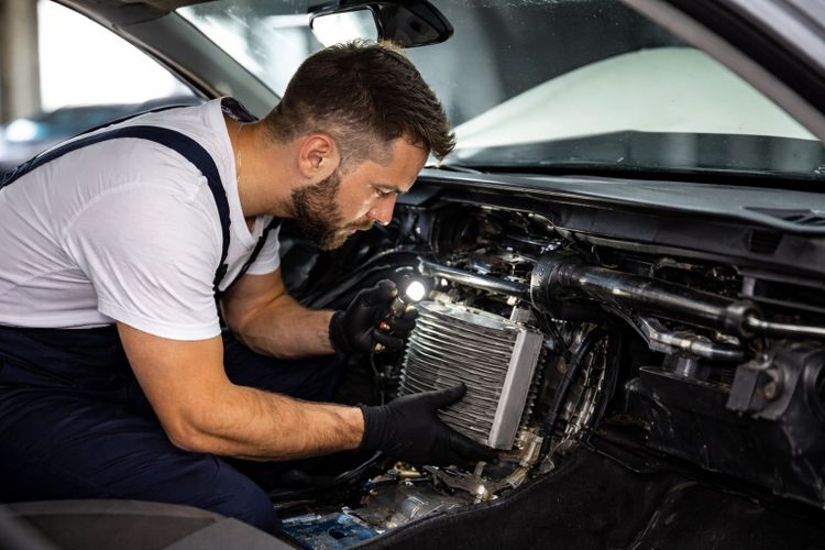 Technician inspecting vehicle heating and air conditioning components in Missouri City TX