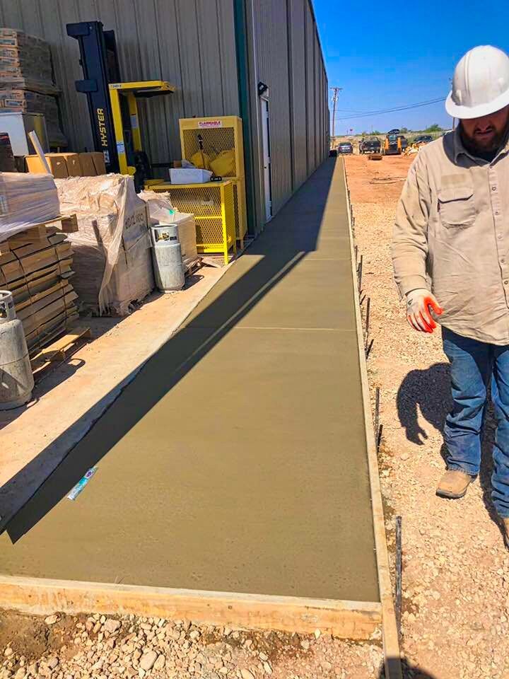 Professional masonry technician finishing a high-traffic industrial floor for a commercial building project in the Sacramento area by Roseville Concrete Solutions.