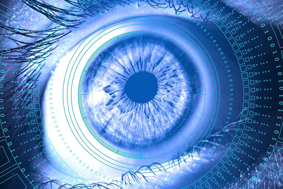 A close-up image of a blue eye surrounded by digital elements and circuits, giving a futuristic and technological appearance.