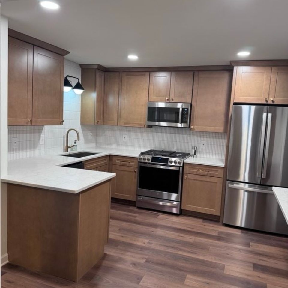Remodeled kitchen with wood shaker cabinets, quartz peninsula, and stainless appliances in a Cleveland east side home