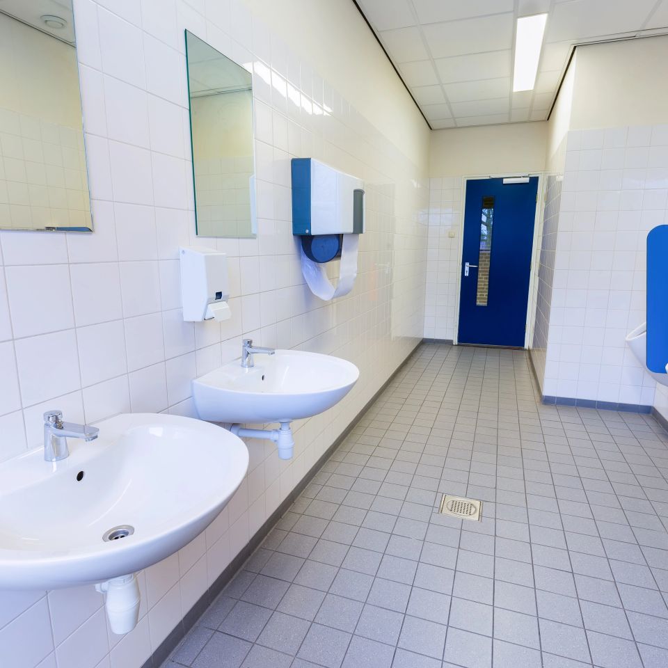 Mens restroom with white urinals and white sinks