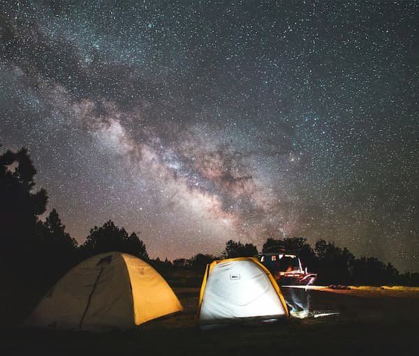 Milky way in the sky above two tents 
