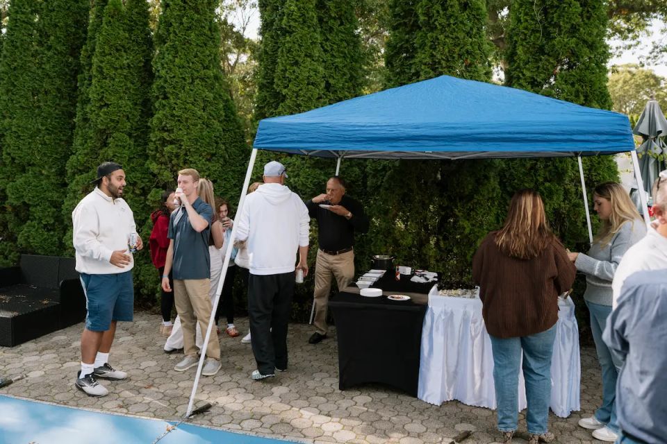 Group of people enjoying raw bar catering in a backyard for a party, by Shore2Shore Shucking of Long Island