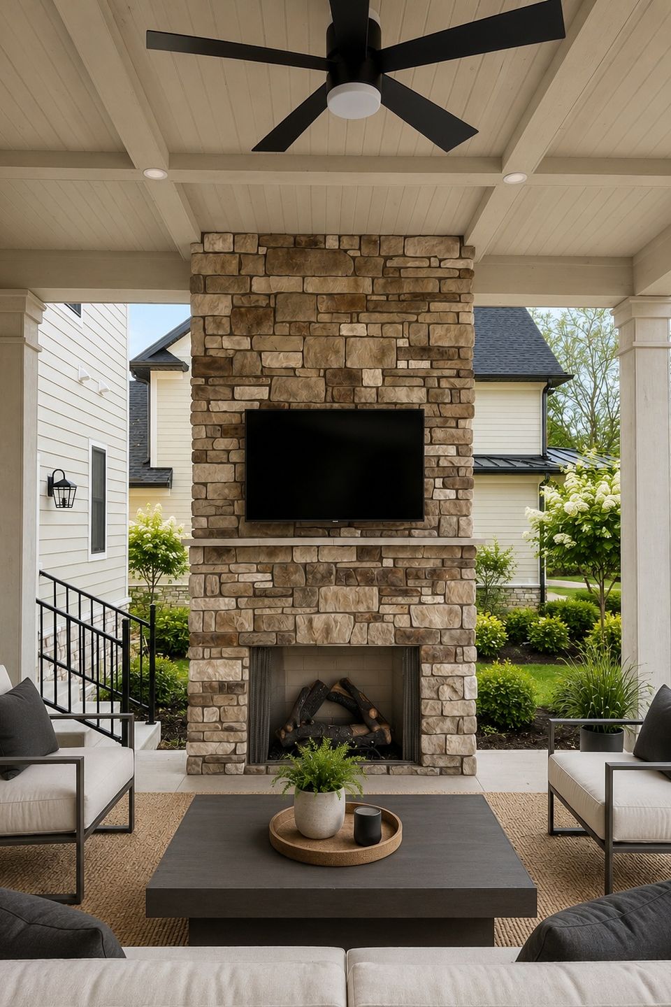 Covered patio with stone fireplace in a custom home in Hudson, Ohio