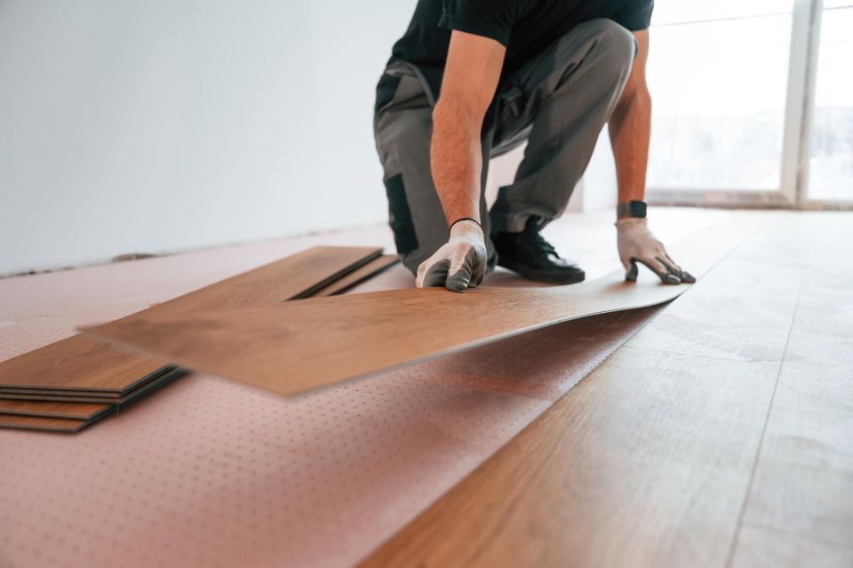 Skilled flooring technician carefully fitting a precision-cut luxury vinyl plank during a professional home installation by Concord Carpet And Hardwood.
