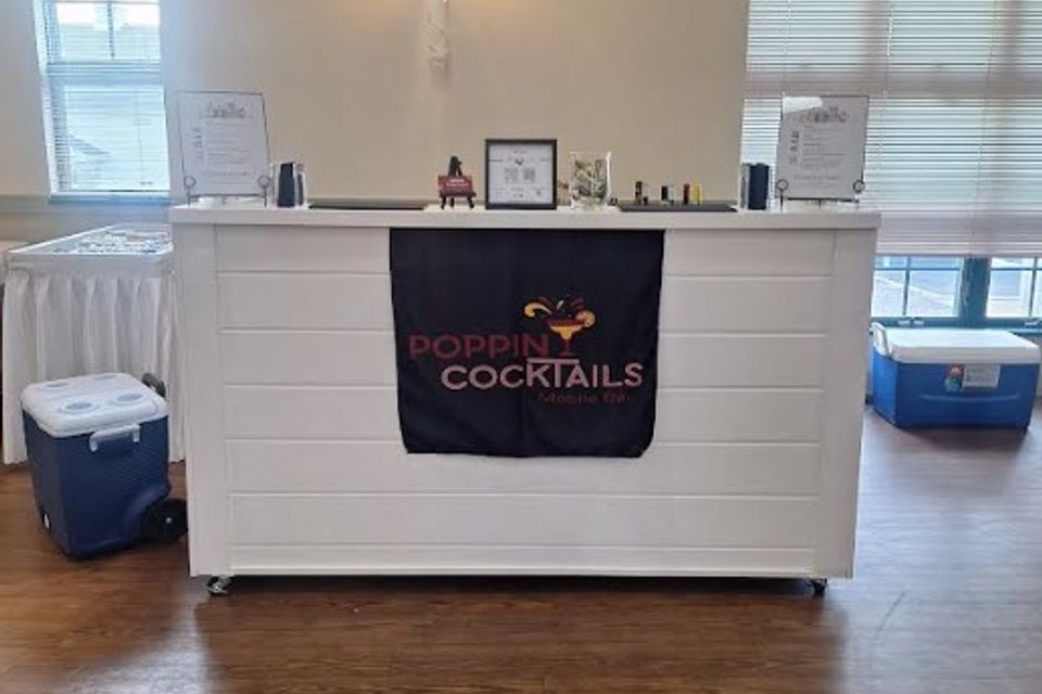 Mobile bar setup with menu, coolers, and supplies arranged for an event