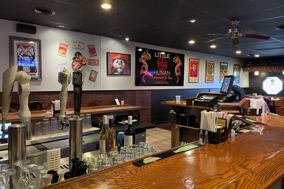 Interior view of Little Hunan Restaurant featuring the bar area, seating, and welcoming dining environment.