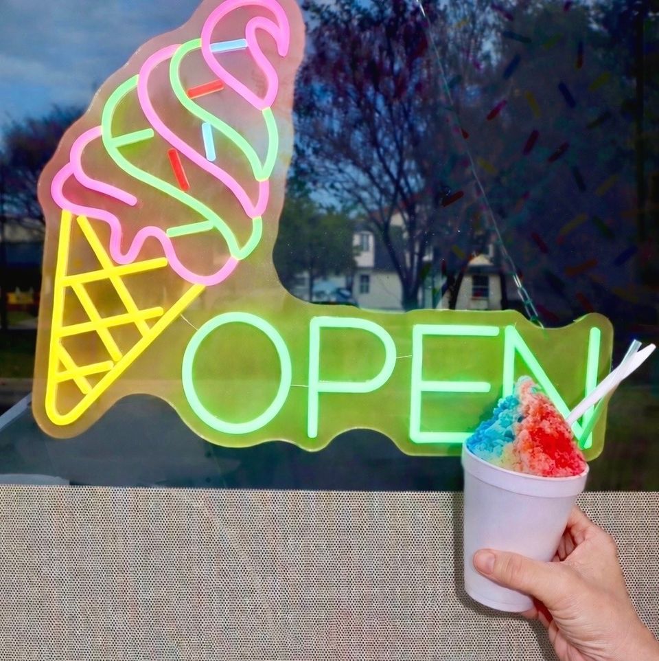 A New Orleans snoball in front of the neon open sign at Bella Boo in New Orleans.