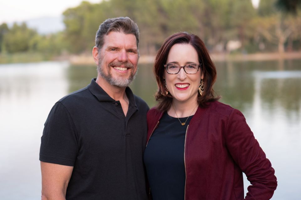 Man and woman posing by lake