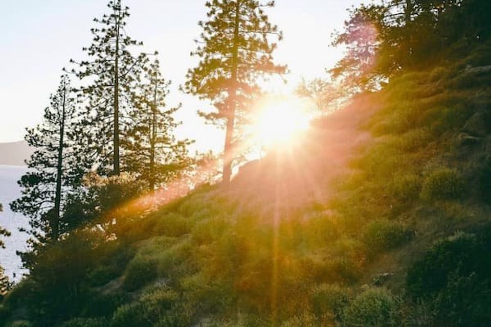 Sun peaking over a mountain on west shore of Lake Tahoe 