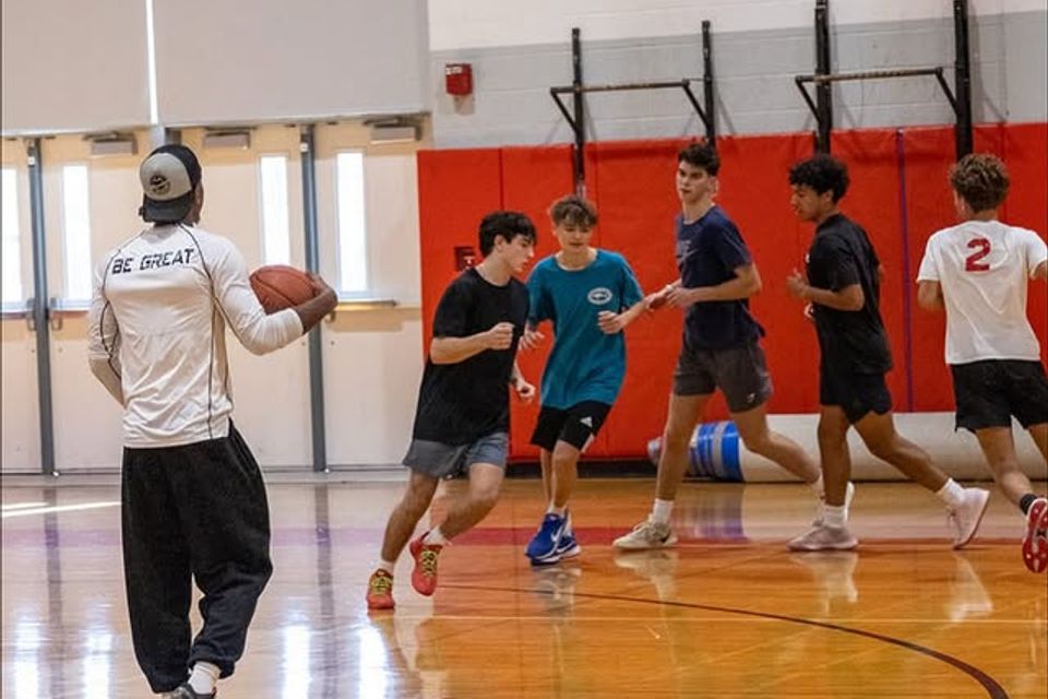 Xavier Allen training students in a basketball gym