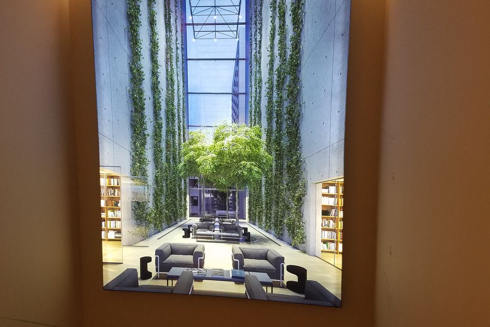Large backlit lightbox panel installed in a building lobby stairwell