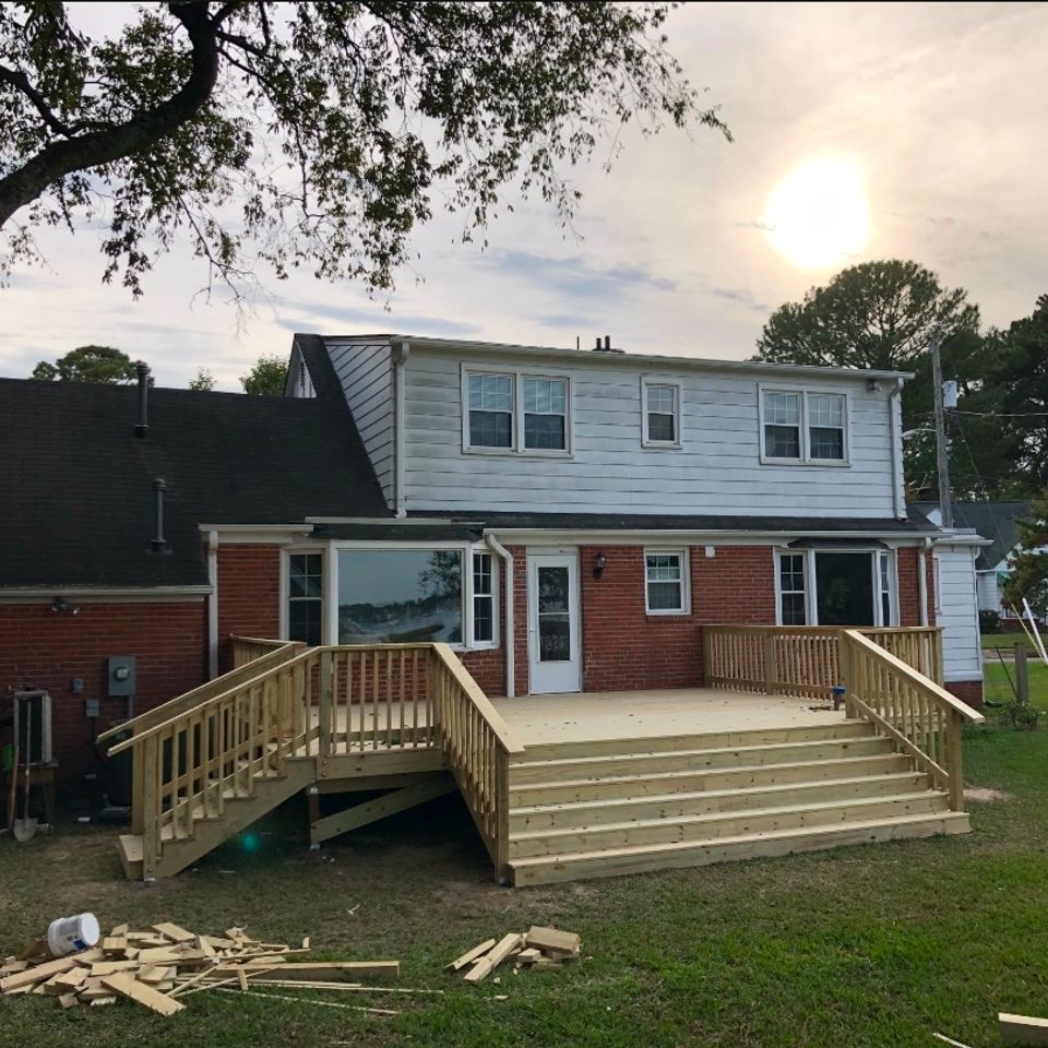 New pressure-treated wood deck with stairs and railings on brick home in Virginia Beach VA