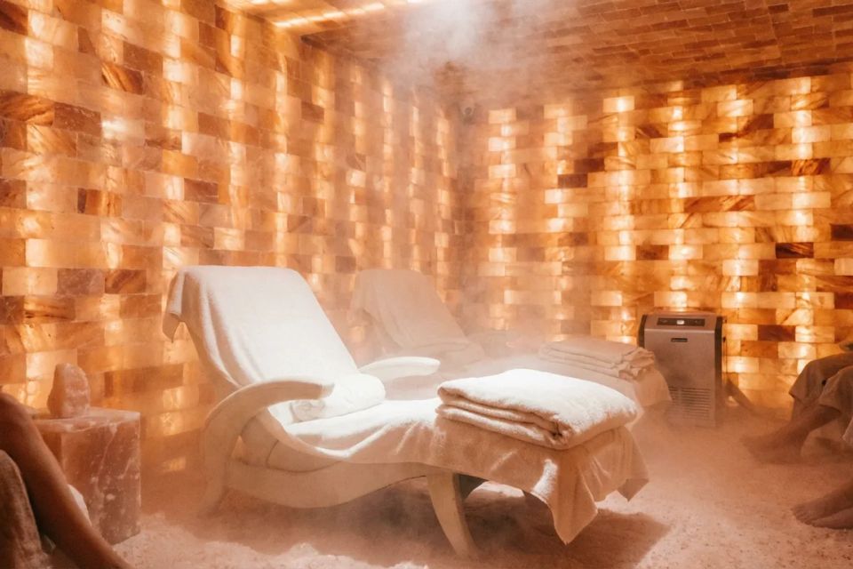 Relaxing salt cave spa room with glowing orange salt brick walls and comfortable lounge chairs