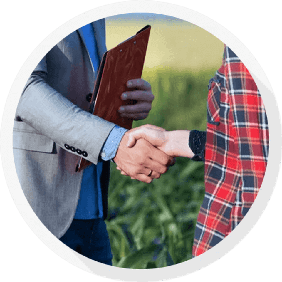 Insurance agent shaking hands with farmer