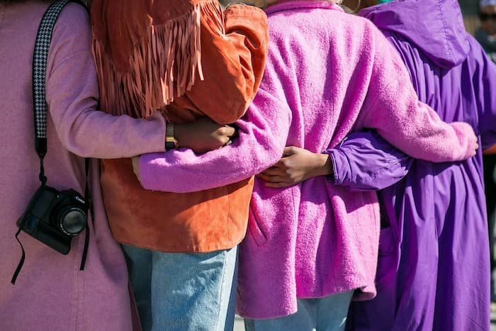 Group linking arms all dressed in bright colors 