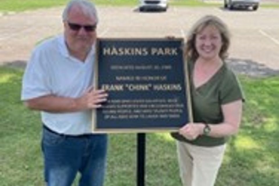 Dow Saunders shares a moment with Joey Pilarzyk, Mr. Haskins' daughter. Their joy is captured as they unveil the replica dedication marker—the original missing. 