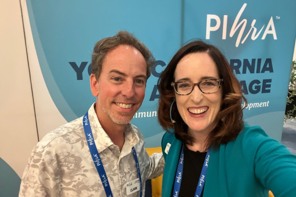 Man and woman posing for photo at an event