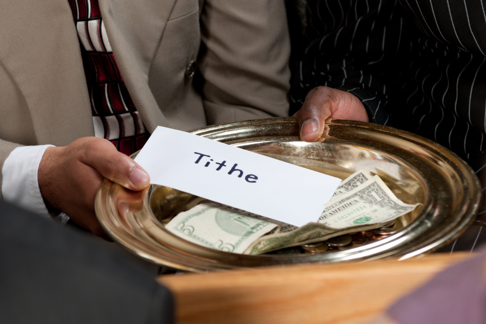 Offering plate containing cash and a tithe envelope, representing faithful giving, stewardship, and support for church ministry.