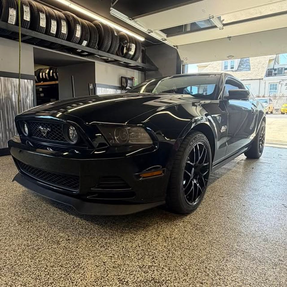 Black Ford Mustang inside tire shop showroom with tire display in Claymont DE