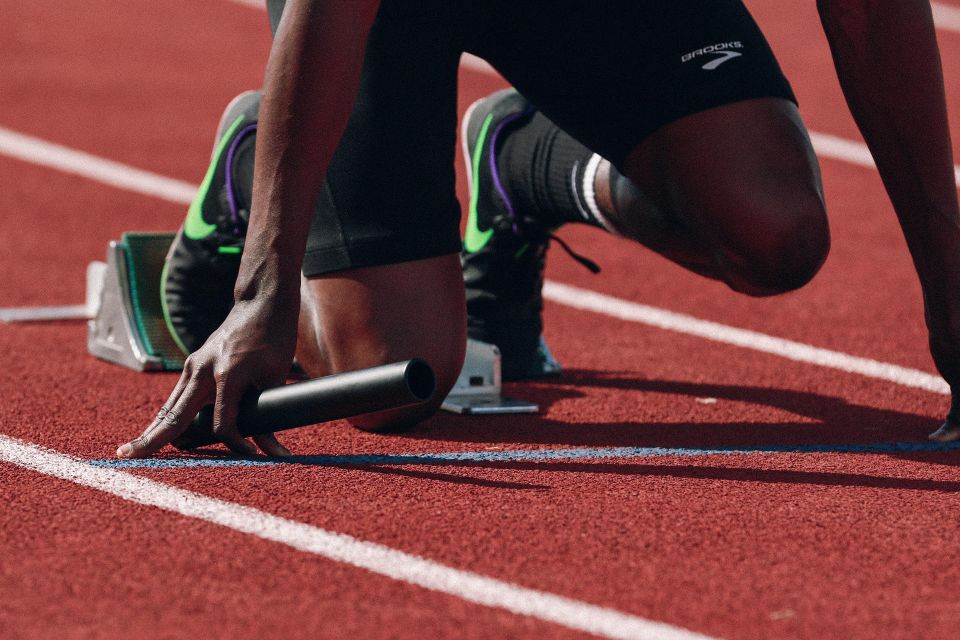 Athlete with baton training and about to start running 