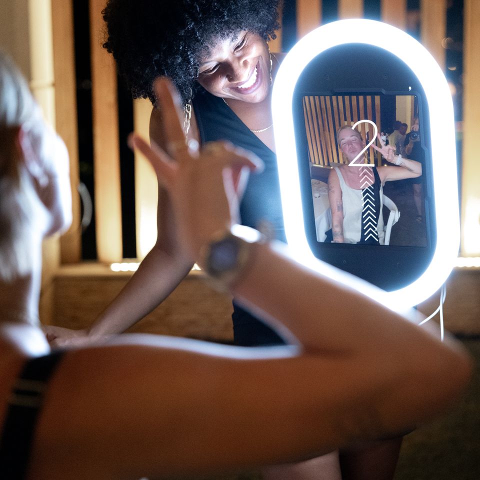Event guests having fun using a roaming photo booth with built-in lighting.