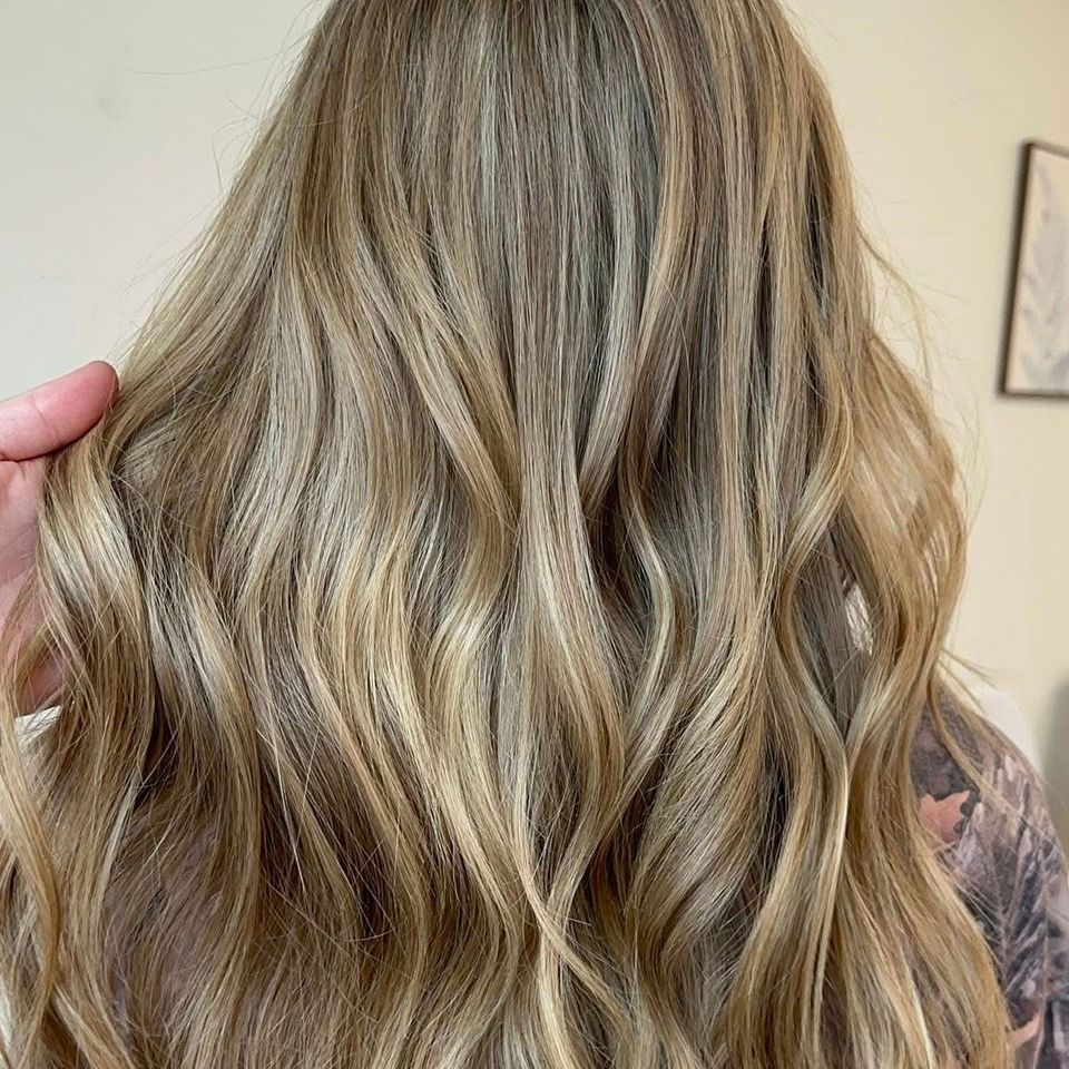 Long wavy dark blonde hair with natural dimension after color and styling in Columbiana AL