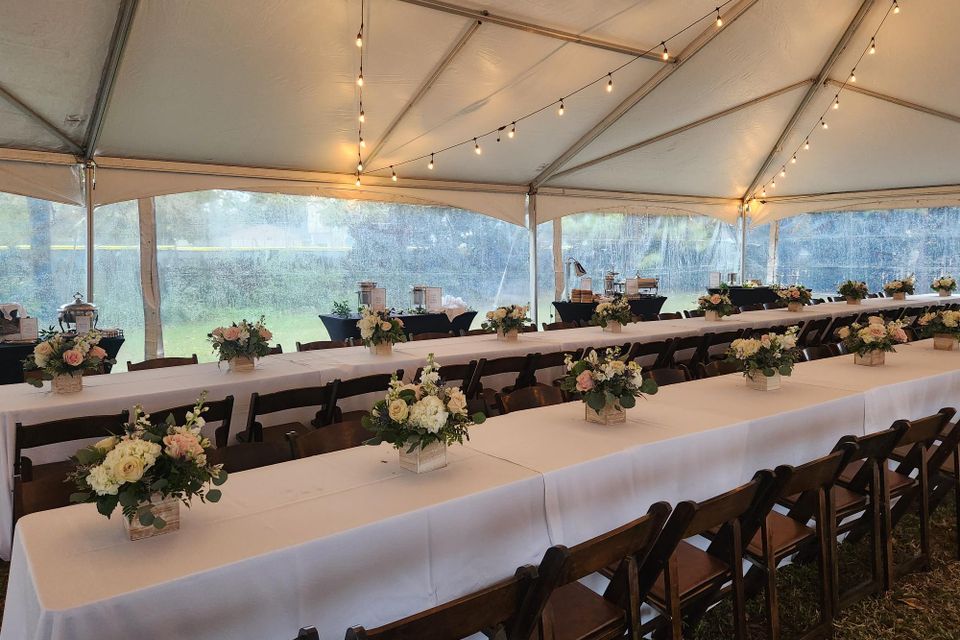 Elegant outdoor reception setup with long banquet tables, floral centerpieces, and string lights coordinated by Carpe Diem Events
