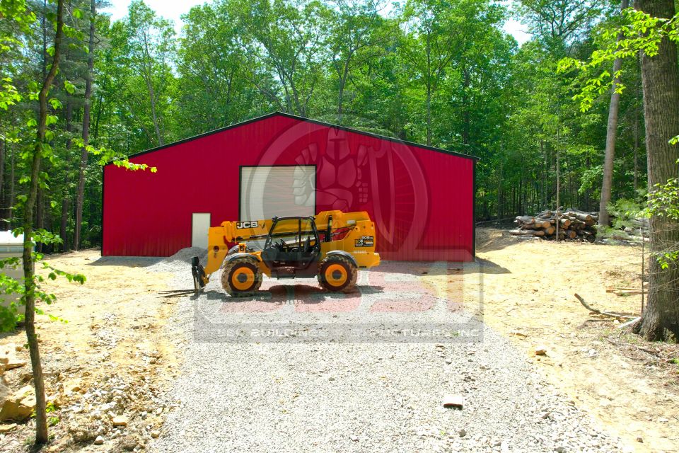 Red steel building with lift equipment parked out front in wooded lot with SBSI watermark representing steel buildings in Alabama