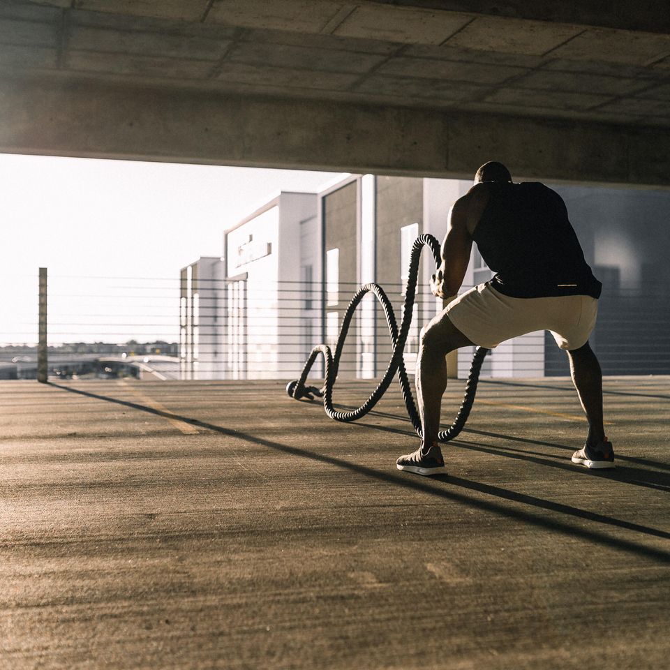Man doing battle ropes in parking structure