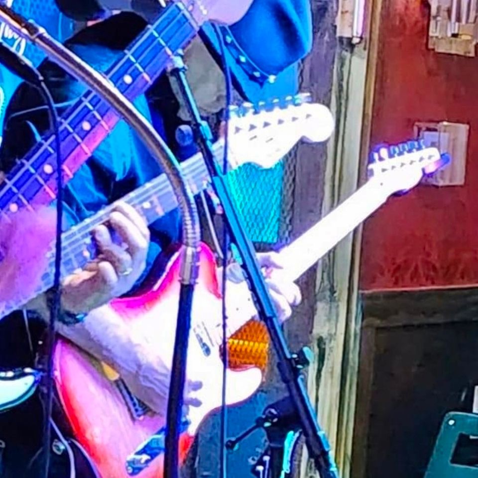 Close up of Roadside guitarists playing electric guitars side by side during a live show