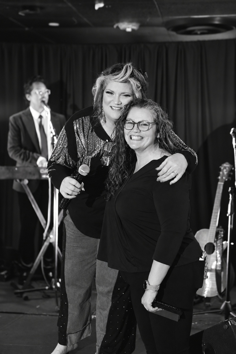 Black-and-white photo of Stacy Wynette with a community supporter at a live event