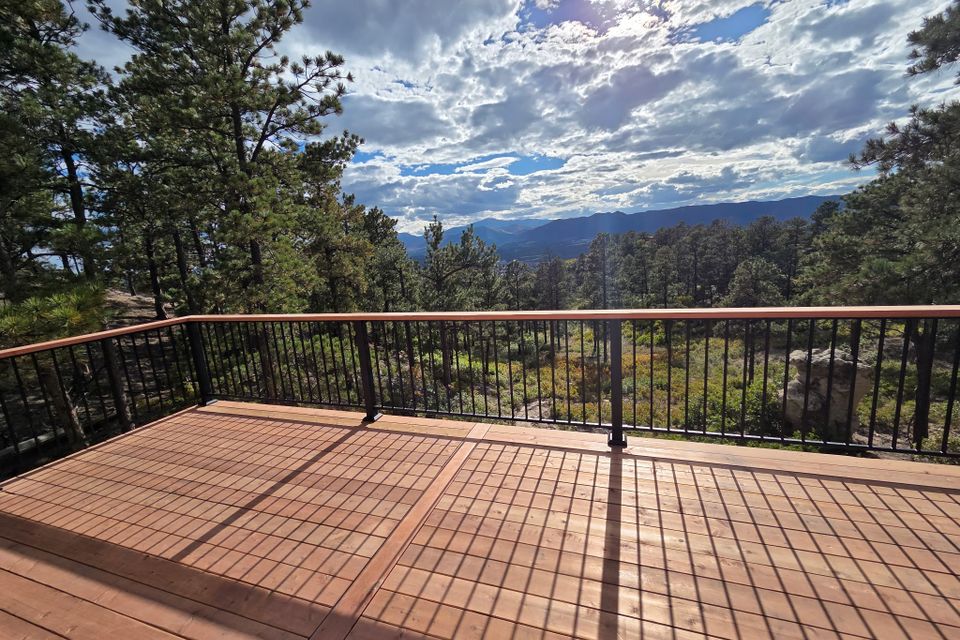Heart redwood deck with metal deck railing has a gorgeous of the foothills of colorado springs