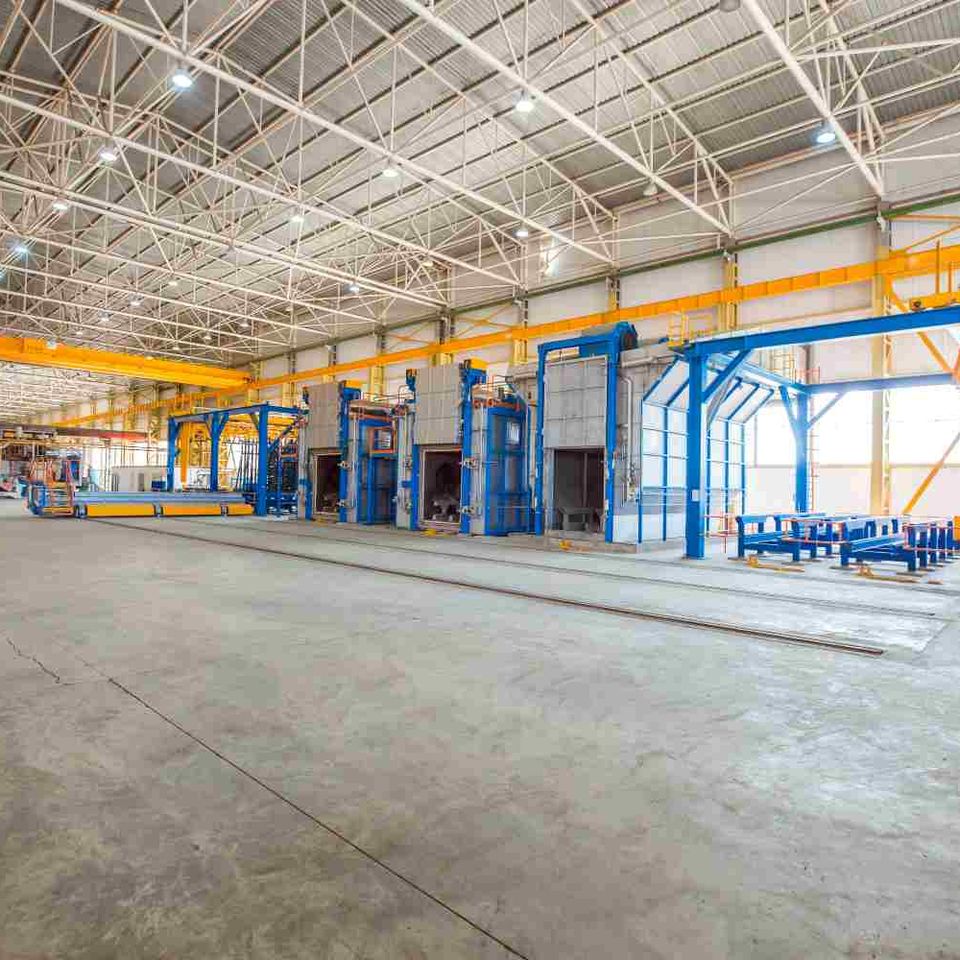 Metallic ovens inside big factory with heavy equipments
