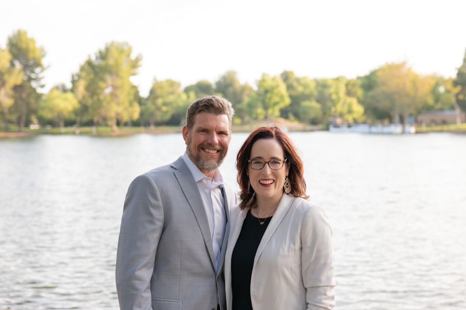 Man and woman posing by lake