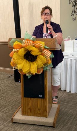 Speaker holding a microphone at a podium during the Mahoning Valley September meeting.