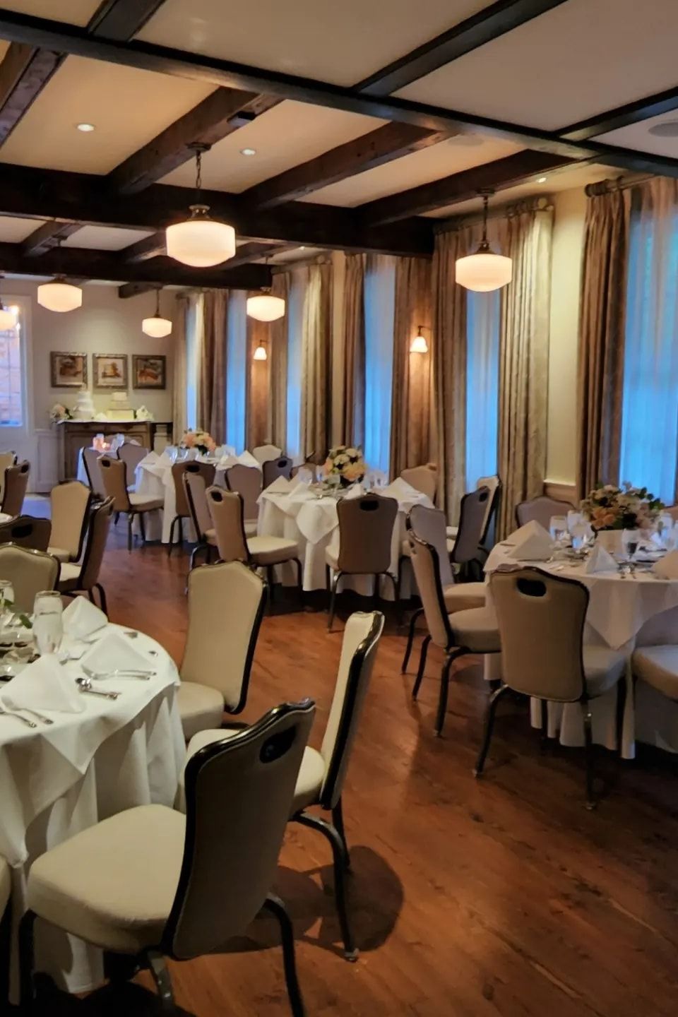 Elegant indoor reception setup with round tables, floral centerpieces, and formal place settings coordinated by Carpe Diem Events