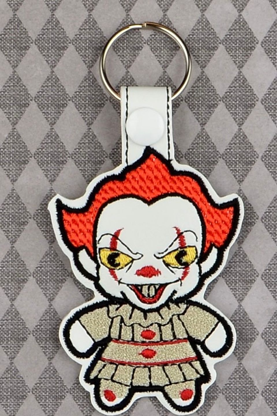 Custom embroidered horror clown keychain with red hair, detailed facial features, and stitched accents.