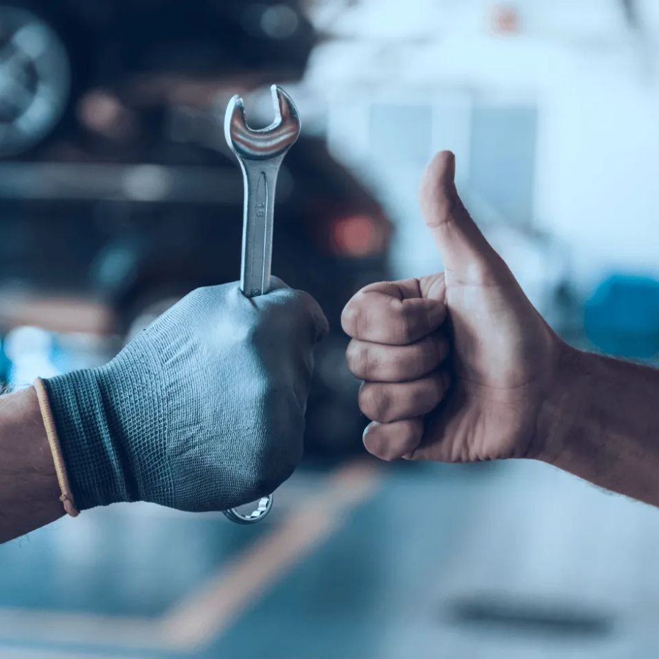 Mechanic holding wrench and person giving thumbs up