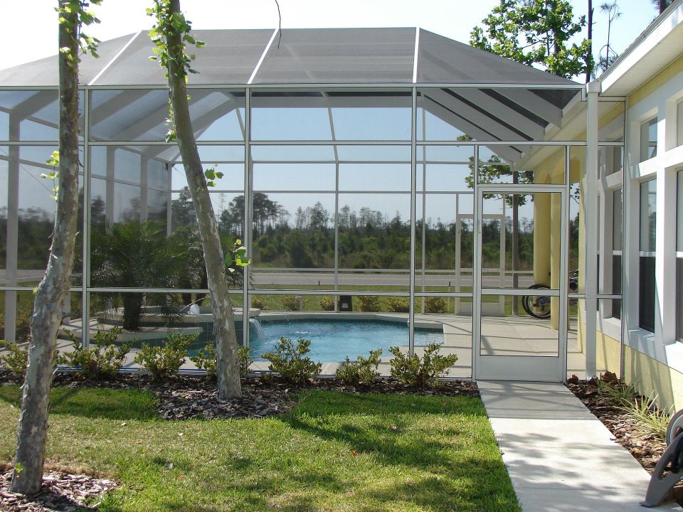 An outdoor screened enclosure over an underground pool