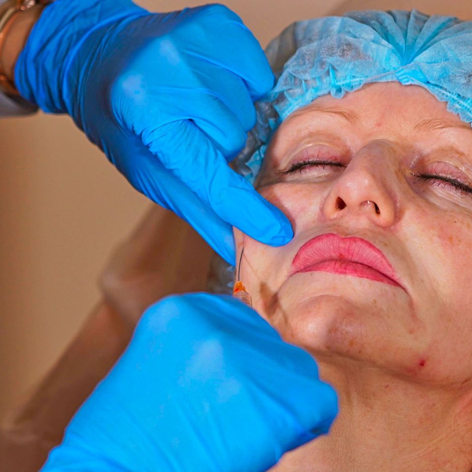 A cosmetologist is a doctor who works in a hospital who injects a cannula into the che sbi 351326147