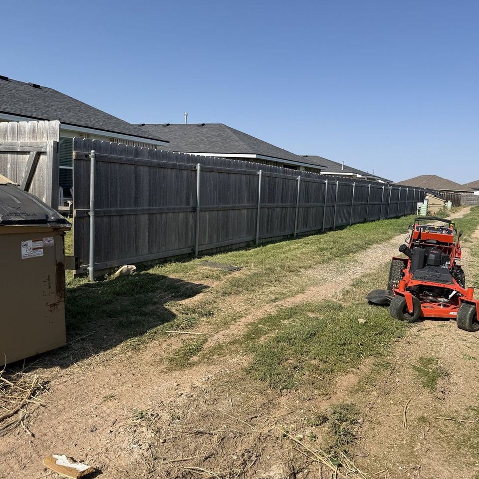 Mowin N Goin stand-on mower clearing an overgrown Lubbock alley