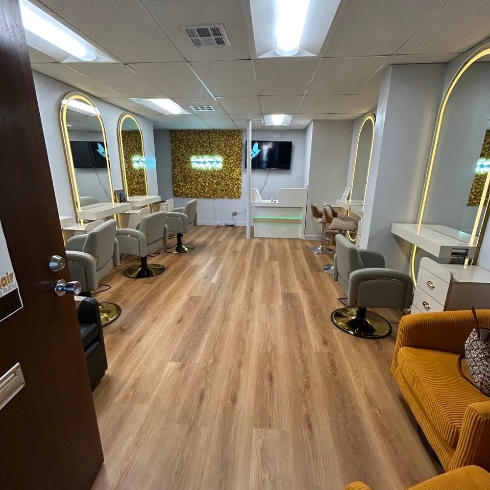 View of the braiding salon floor with styling stations mirrors and gold seating area in Los Angeles CA
