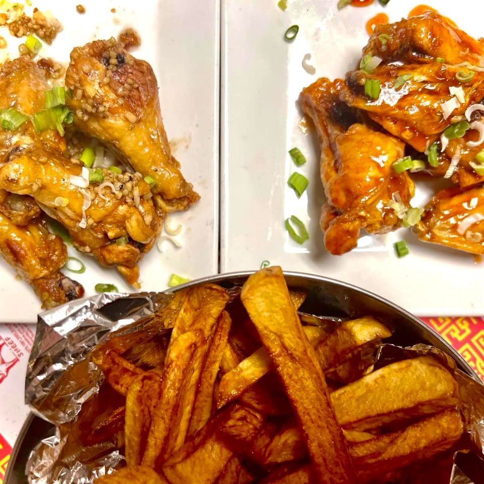 Assorted appetizers and wings served with seasoned fries and garnished with green onions.