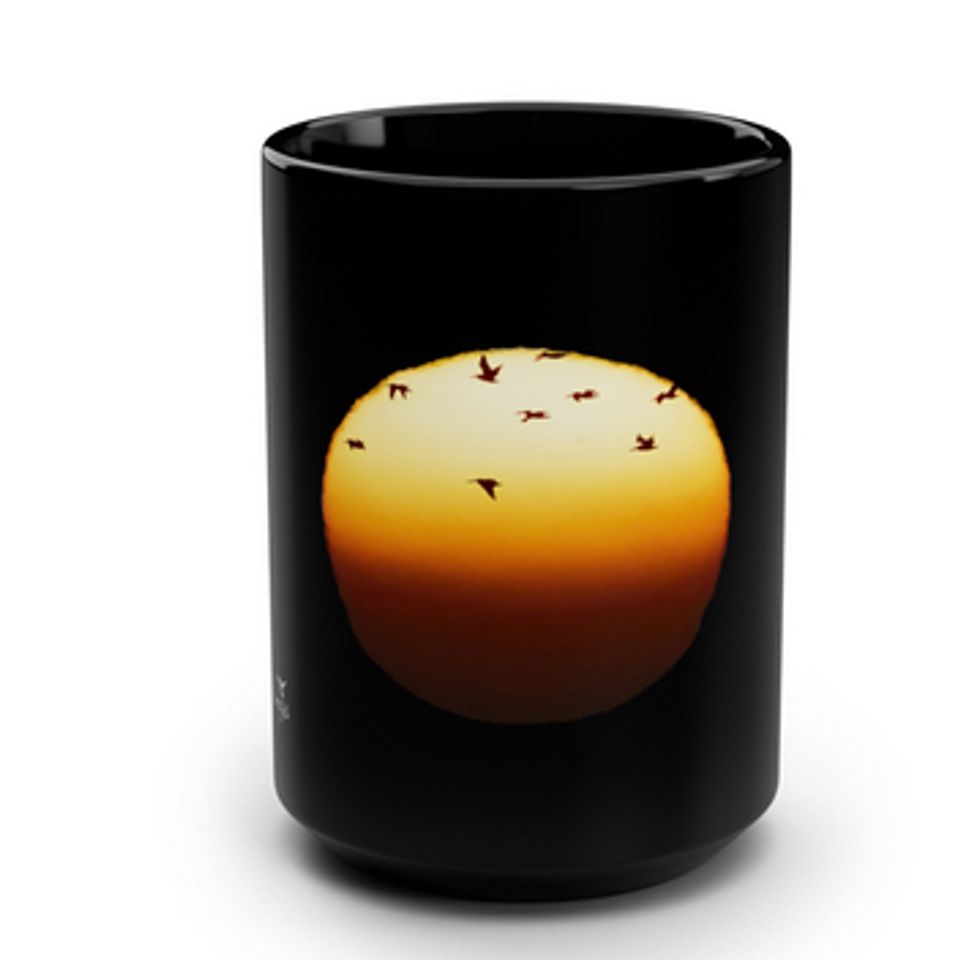 Pelicans flying across the sun black mug