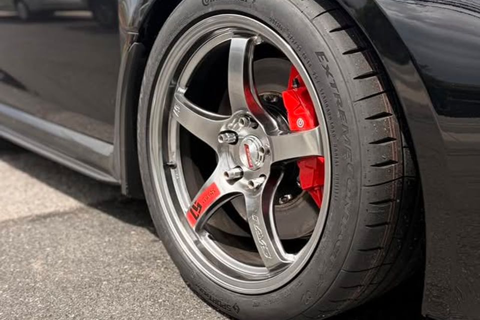 Close-up of sports car wheel with Continental tire and red Brembo brake caliper in Claymont DE