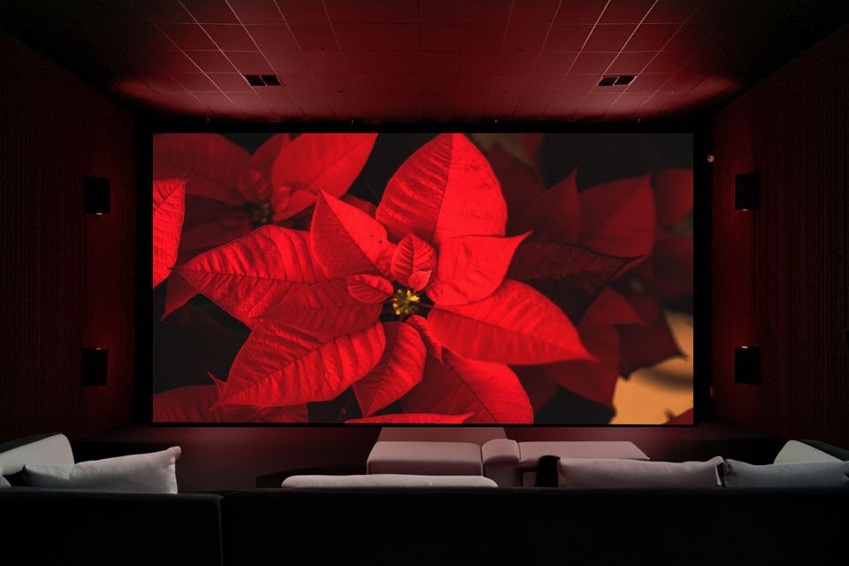 Luxurious home theater with comfortable seating, a large screen, and surround sound speakers.