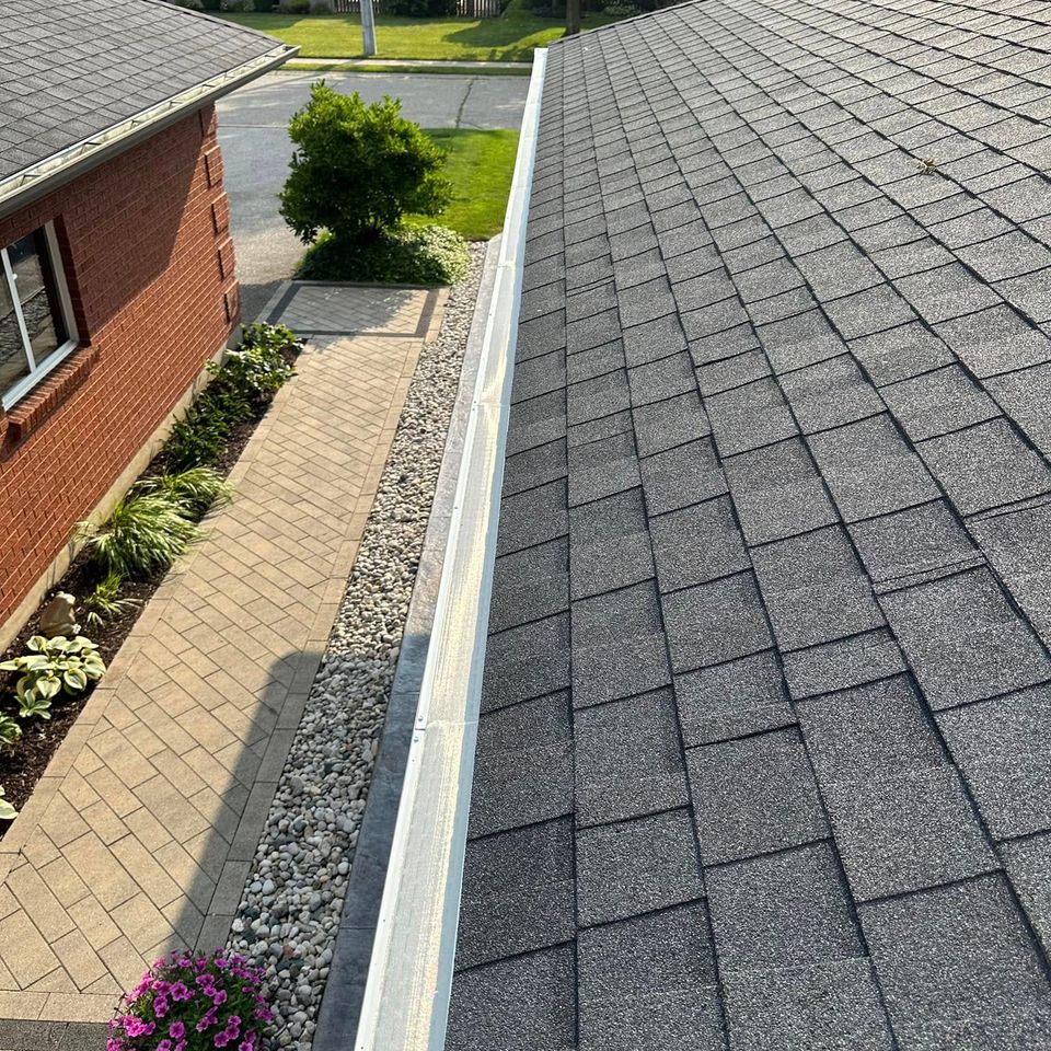 Debris-free gutter running along a shingled roof after gutter cleaning in Tillsonburg Ontario