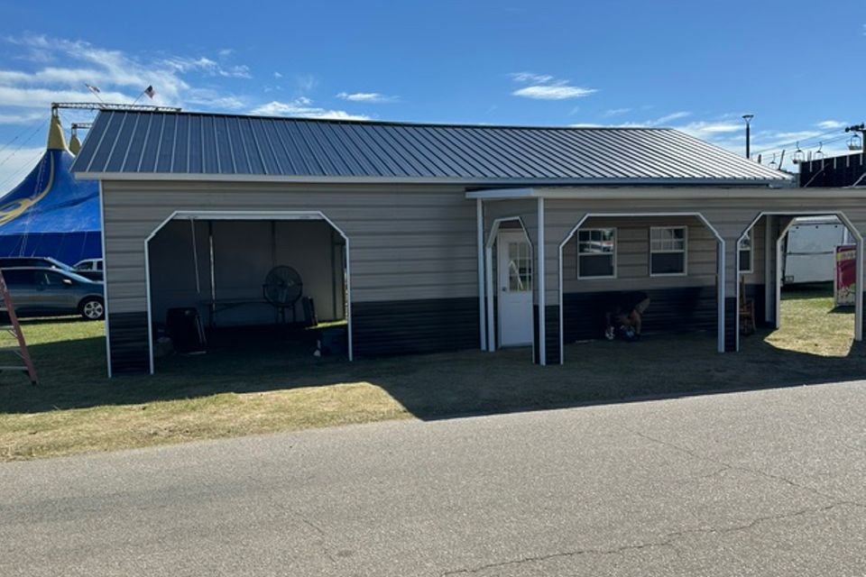 Tan steel building with double carport bays and metal roof representing steel carports in Alabama